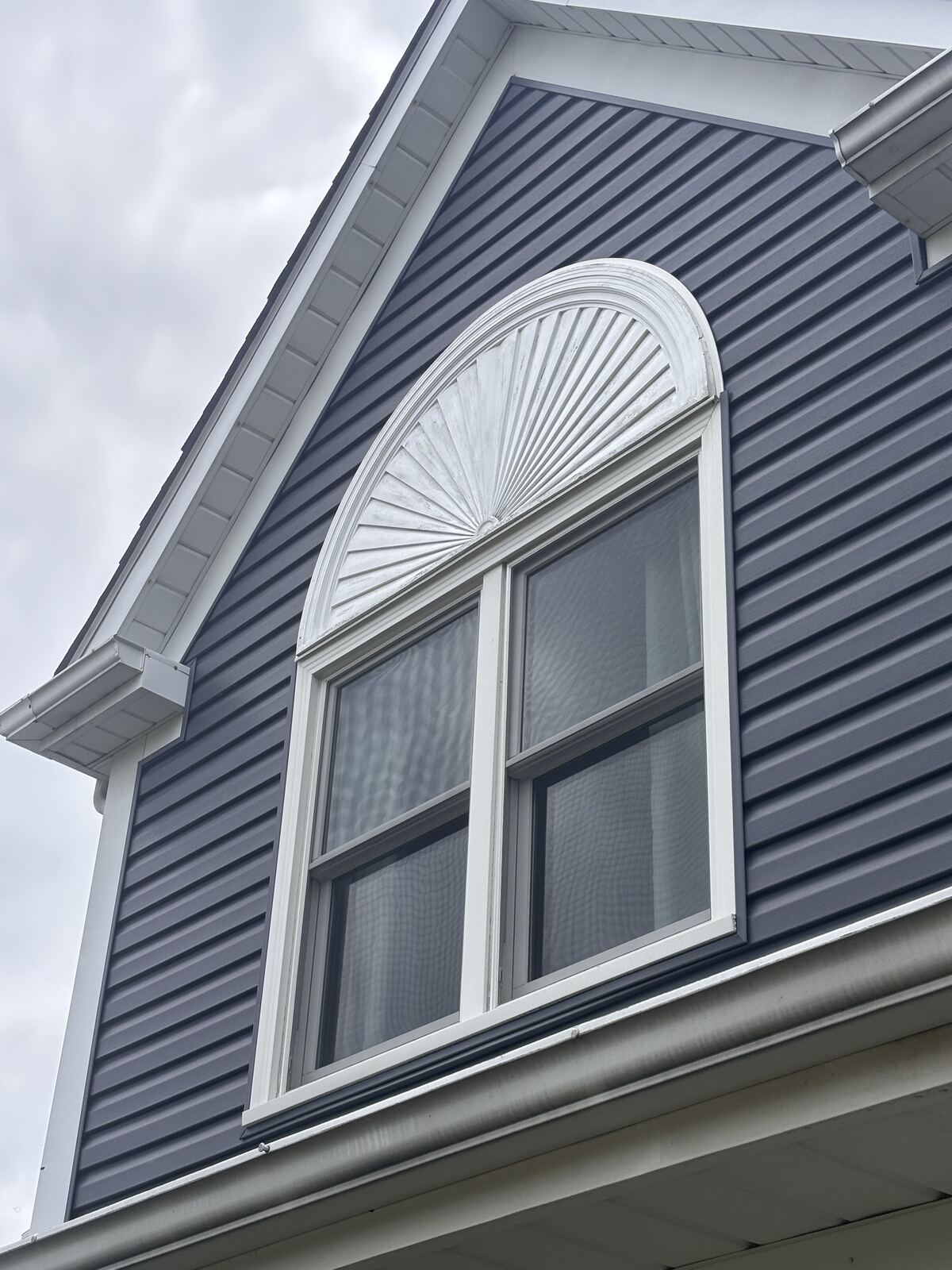 Clean dormer window with sunburst trim detail