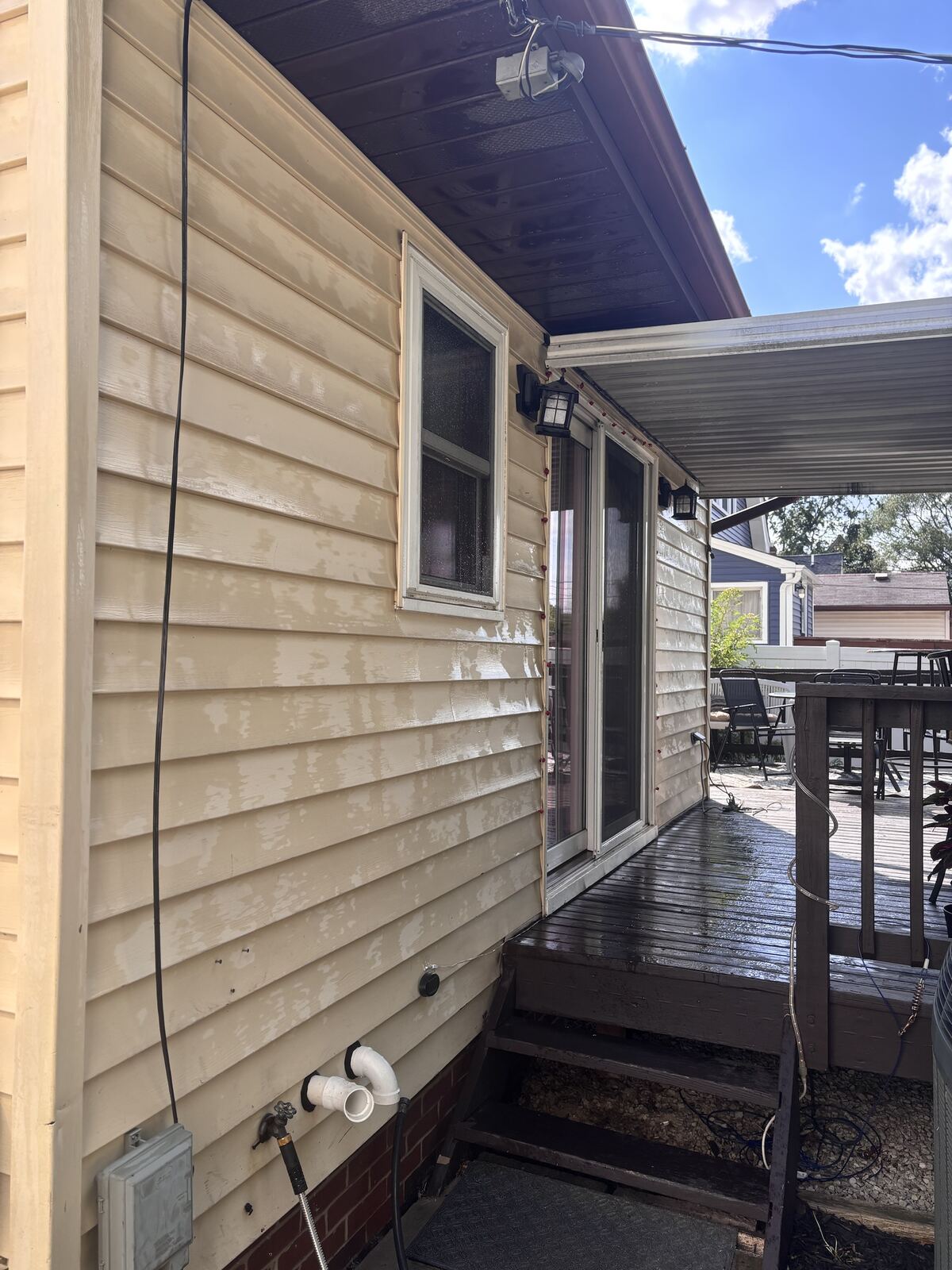 Soft washing siding, suds and rinse water running down the wall