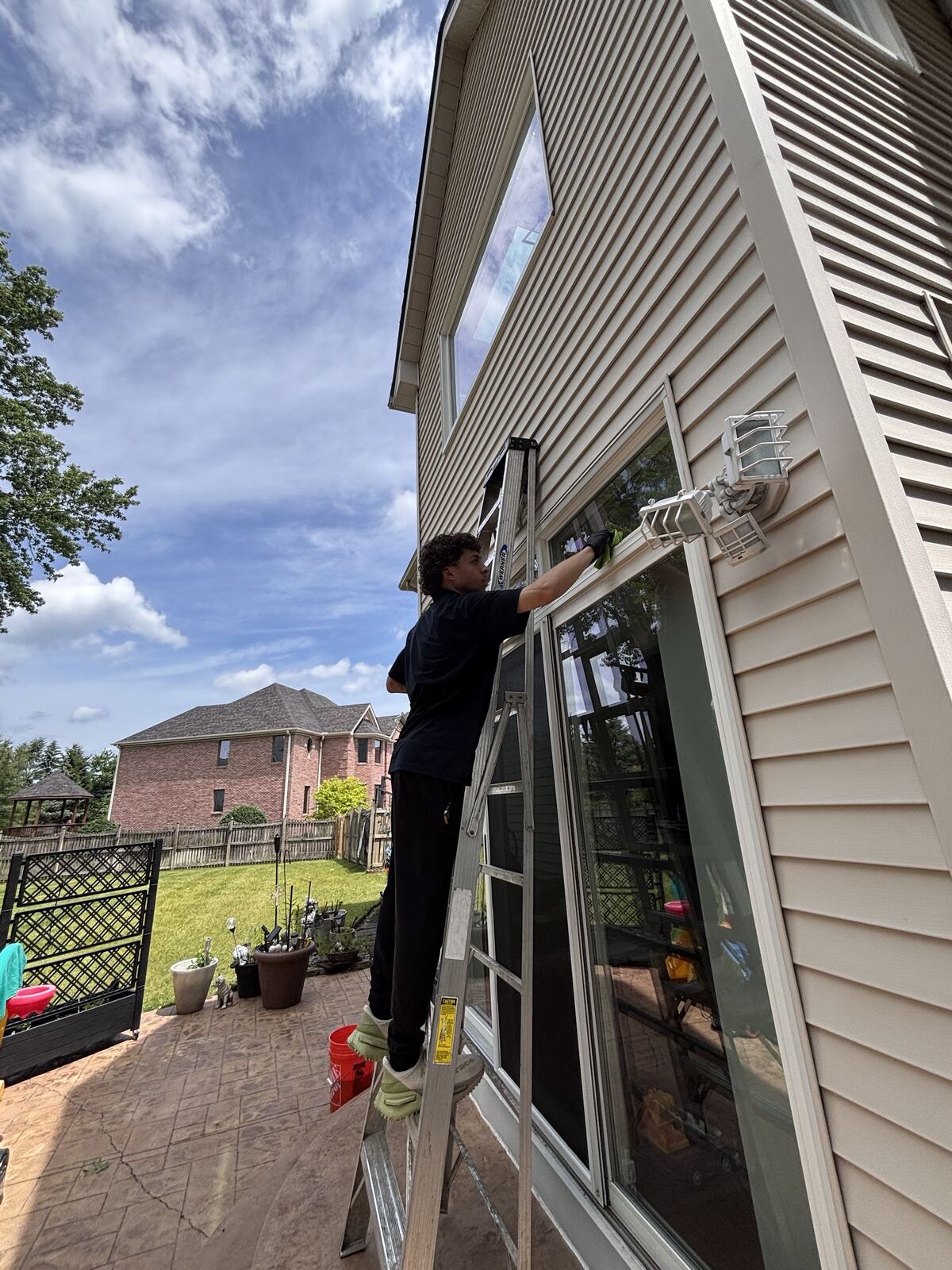 Crew member on a ladder cleaning a window